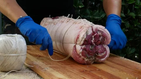 Butcher binds meat rolled up for pochette roast pork Video stock 242080199
