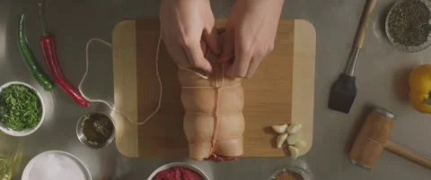 Butcher binds meat rolled up for pochette marinated roast pork, Culinary show Stock Footage 288144964