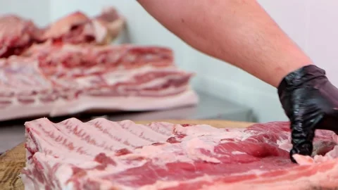 The butcher chops raw pork meat with sharp axe at meat processing plant. Stock Footage 181016754