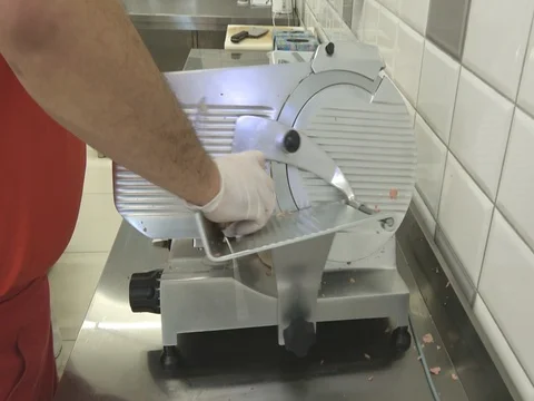 Butcher cut salami on a machine for shredding Stock Footage