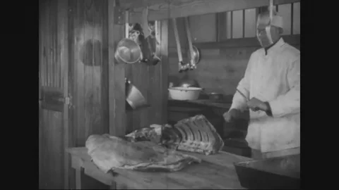 Butcher cuts the beef ribs, chefs in kitchen serving beans in a dish - 1917-1918 Stock Footage 83702549