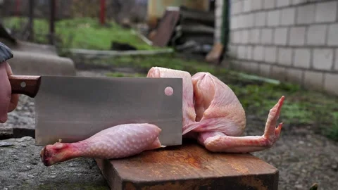 A butcher cuts up a chicken carcass with a kitchen cleaver Stock Footage 326029331