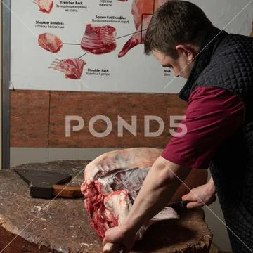 A butcher cuts lamb into minced meat Stock Photos