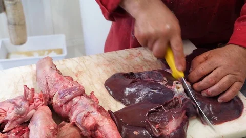 Butcher cuts liver on a table Stock Footage 84776705
