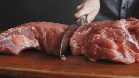 Butcher cuts meat with knife Stock Footage 112949913