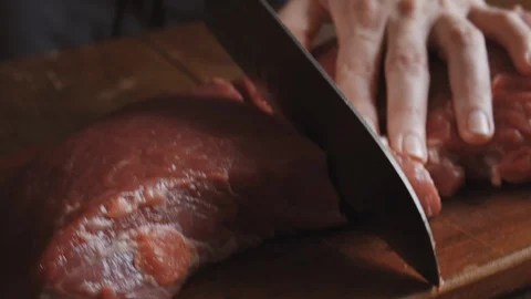 Butcher cuts meat with knife Stock Footage 112950394