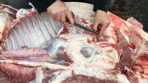 Butcher cuts off a piece of meat from in... | Stock Video | Pond5