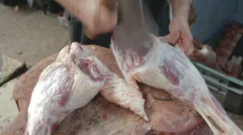 Butcher cutting back part of mutton on wooden frame Stock Footage 8367850