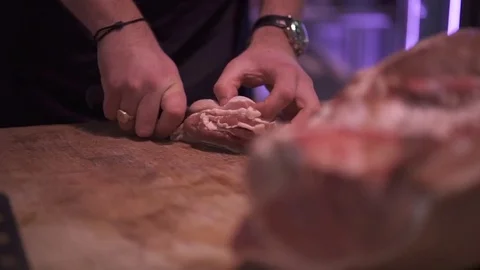 Butcher cutting bacon with a sharp knife Stock Footage 83187571