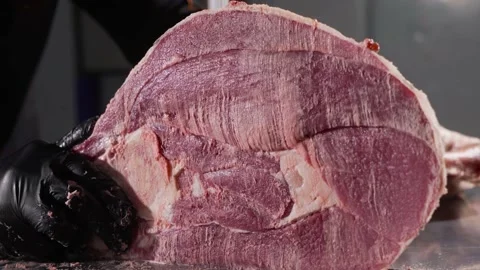 A butcher cutting up meat with a large table saw in a butchery. Meat production 스톡 동영상 239400777