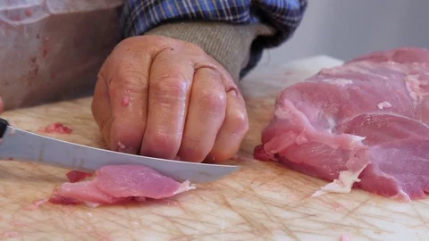 A butcher cutting pork meat on the table. Close-up, slow motion. Stock Footage 83727312