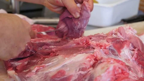 A butcher cutting pork meat on the table. Close-up. Stock Footage 83729014