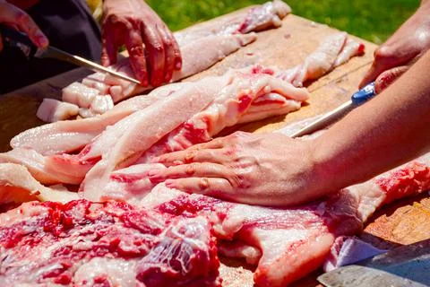 Butcher is cutting, processing fresh meat Stock Photos