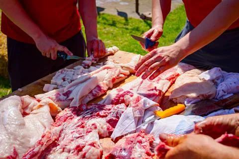 Butcher is cutting, processing fresh meat Stock Photos