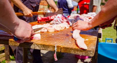 Butcher is cutting, processing fresh meat Stock Photos