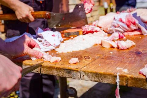 Butcher is cutting, processing fresh meat Stock Photos