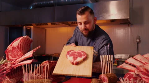 Butcher displaying heart shape raw fresh meat beef ribeye steak. Video stock 295262097