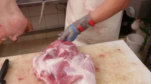 Butcher extracting bone off pig ham Stock Footage 41467310