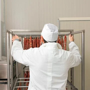 Butcher hangs sausage Stock Photos
