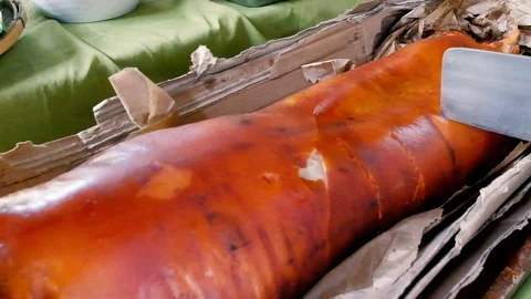 Butcher knife slicing the popular and delicious roasted pig or "lechon baboy" Stock Footage