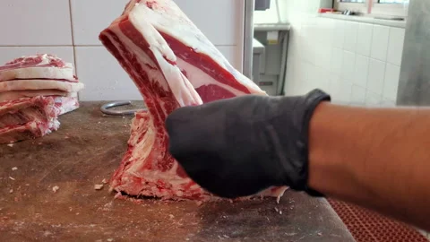 Butcher man work on cutting beef t-bone steak meat using safety gloves,food Stock Footage 160438571