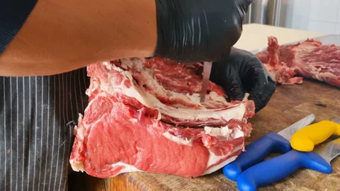 Butcher man work on deboning beef steak meat using safety gloves,food profession Stock Footage 238976852