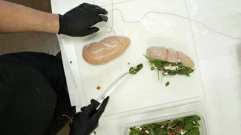 Butcher preparing chicken breast stuffed with herbs and cheese 動画素材 83457339