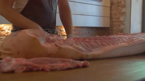 Butcher preparing a large piece of pork on the table to cook Stock Footage 137900554