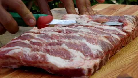 Butcher preparing rack of pork ribs for cooking Video stock 238486587
