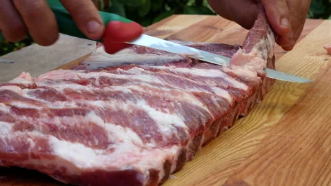 Butcher preparing rack of pork ribs for cooking 스톡 동영상 238486604