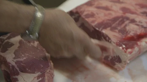 Butcher preparing raw beef Stock Footage 104872858