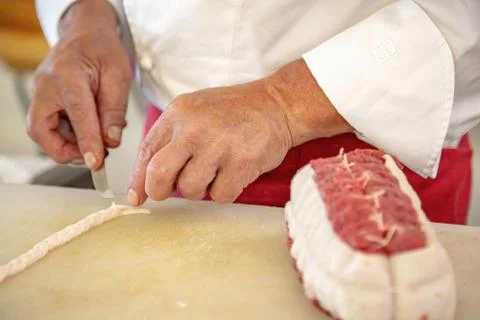 Butcher preparing a rosbeef on his work plan Stock Photos