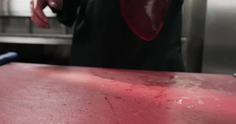 Butcher puts throws raw fresh beef liver on a cutting board. Close-up slow Stock Footage 294231986
