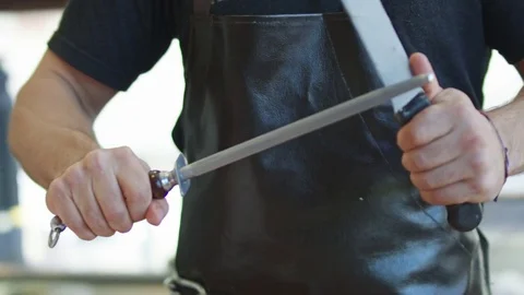 Butcher Sharpening Blade in Slow Motion Stockbeeldmateriaal 77396608