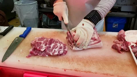 A butcher skillfully slicing fresh meat Stock Footage 310529003