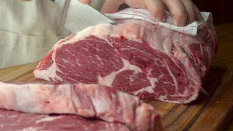 Butcher slicing chunk of beef rib eye Stock Footage 143798978