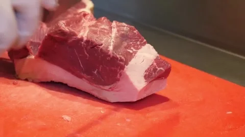 Butcher Slicing Fresh Raw Beef Roast on Red Cutting Board Stock-Footage 332812026