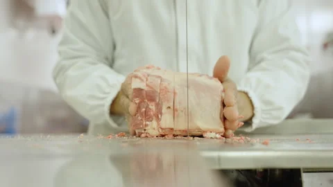 Butcher Slicing Large Lamb Rib Section on Bandsaw Stockbeeldmateriaal 341308567