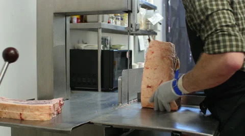 Butcher using bandsaw to cut beef in butcher shop Stock Footage 50055898