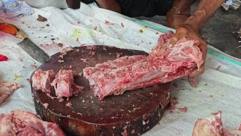 Butcher using a cleaver to chop raw pork ribs Stock-Footage 346769606