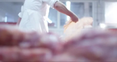 Butcher in white work clothes handles fresh meat in a bright processing plant Video stock 339987462