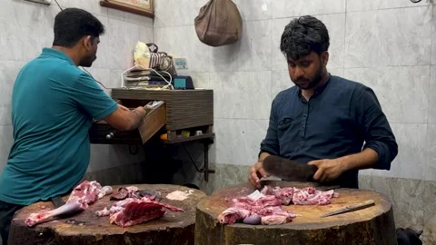 Butcher working inside a Indian meat shop. Chopping raw mutton on a wooden block Stock Footage 336942686