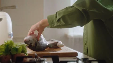 Butchering dorado fish in a kitchen setting with fresh ingredients and tools Video stock 294914581
