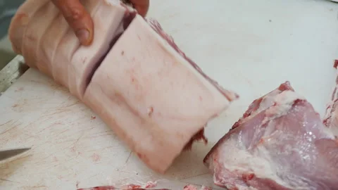 The butcher's hands holding a large sharp knife cut pork entrecote on a cutting  Stock Footage 232151177