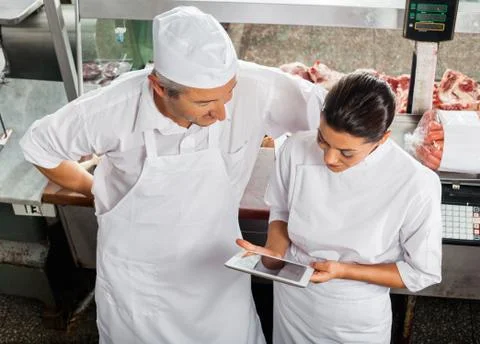 Butchers Using Digital Tablet In Store Stock Photos