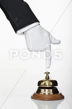 A butler pushing a service bell, focus on hand Stock Photos
