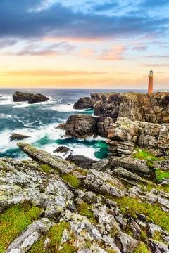 Butt of Lewis Lighthouse at Sunset on Rugged Atlantic Coastline with Crashing Stock Photos