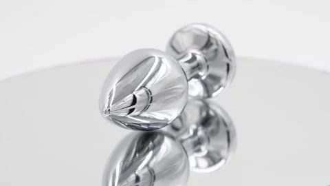 Butt plug spinning on mirror surface Stock Footage 277357460