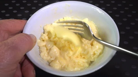 Butter being mixed into scrambled eggs. Video stock 97777366