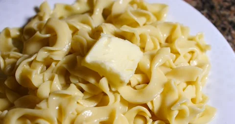 Butter being placed on a pile of egg noodles ready to eat Video stock 150991038